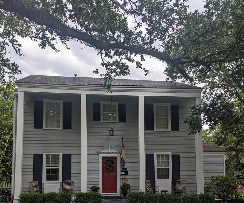 Two-story home: gray siding, black shutters, red door