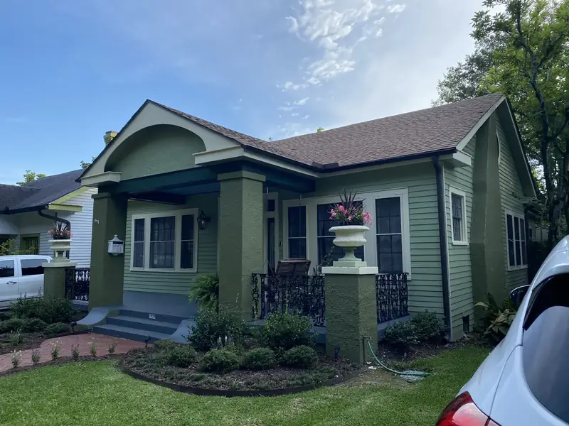 Craftsman home in green, white window trim